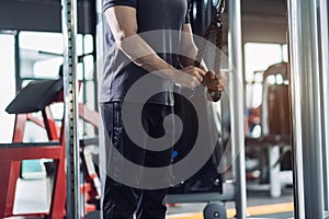 Sportsman doing exercises with cable machine tricep in the fitness gym