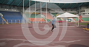 Sportsman doing high jump on stadium