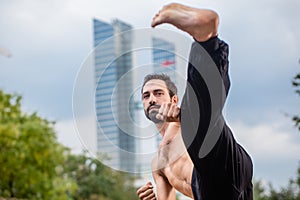 Sportsman doing karate kick in city downtown