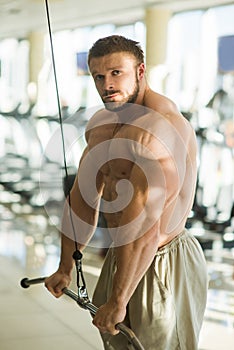 Sportsman doing pull-ups in gym.