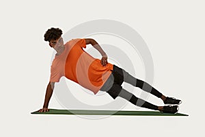 Sportsman doing side plank exercise on fitness mat