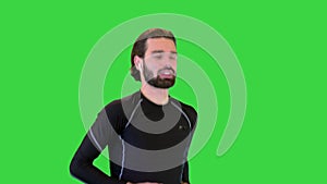 Sportsman with ear buds running and listening to music on a Green Screen, Chroma Key.