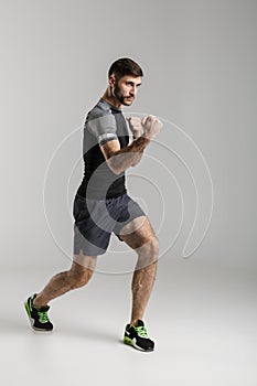 Sportsman fighter isolated over grey wall background