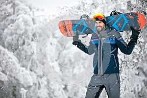 Sportsman holding ski board and return from skiing terrain