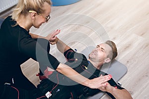 Sportsman lying on floor training with coach