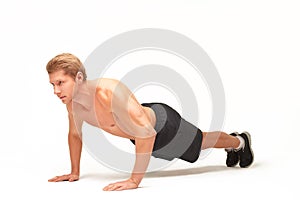 Sportsman making push-ups on palms in studio with bent arms