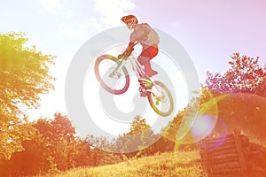 Sportsman on a mountain bike is flying in a jump from a springboard