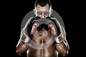 Sportsman Muay Thai boxer celebrating flawless victory in boxing cage. Isolated on black background with smoke. Copy