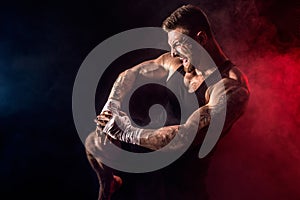 Sportsman muay thai boxer fighting on black background with smoke.