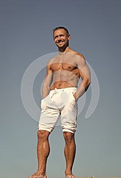 Sportsman muscular belly posing. Man muscular body posing confidently with hands in pockets. Sport and bodycare