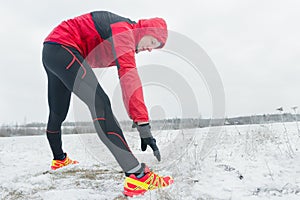 Sportsman during outdoor winter training session at snowy field background