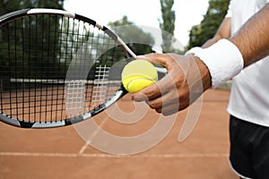 Sportsman preparing to serve tennis ball at court, closeup