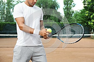 Sportsman preparing to serve tennis ball at court, closeup