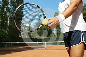 Sportsman preparing to serve tennis ball at court, closeup