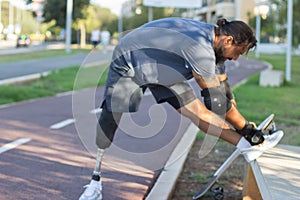 Sportsman with prosthetic leg getting ready for training