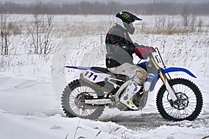 Sportsman racer man fulfills a fast ride on a motorcycle on the road extreme. The race track is very uneven.