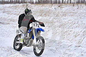 Sportsman racer man fulfills a fast ride on a motorcycle on the road extreme. The race track is very uneven.