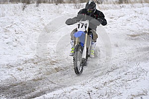 Sportsman racer man fulfills a fast ride on a motorcycle on the road extreme. The race track is very uneven.