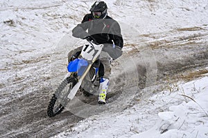 Sportsman racer man fulfills a fast ride on a motorcycle on the road extreme. The race track is very uneven.