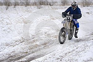 Sportsman racer man fulfills a fast ride on a motorcycle on the road extreme. The race track is very uneven.