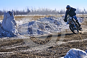 Sportsman racer man fulfills a fast ride on a motorcycle on the road extreme. The race track is very uneven.