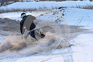 Sportsman racer man fulfills a fast ride on a motorcycle on the road extreme. The race track is very uneven. Photo as the racer p