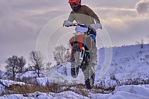 Sportsman racer man fulfills a fast ride on a motorcycle on the road extreme. The race track is very uneven. Photo as the racer p