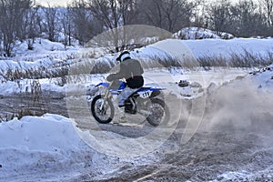 Sportsman racer man fulfills a fast ride on a motorcycle on the road extreme. The race track is very uneven. Photo as the racer p