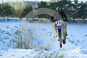 Sportsman racer man fulfills a fast ride on a motorcycle on the road extreme. The race track is very uneven. Photograph of a spor