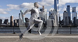 The sportsman running at view to New York. Man sportsman running for exercise in active wear. Sportsman jogger running