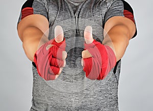 sportsman's hands wrapped in red elastic sports bandage show a like sign