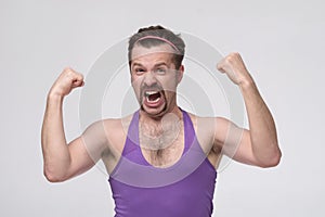 Sportsman screaming and raising clenched fists being excited with his results