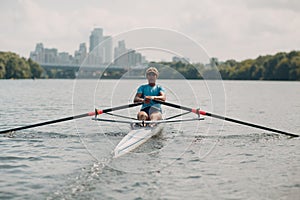 Sportsman single scull man rower rowing on boat