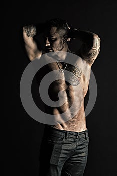 Sportsman with six pack and ab. Tattooed man show sexy muscular torso. Bodybuilder with biceps and triceps. Fashion