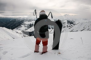 Sportsman in ski equipment with snowboard in his hand