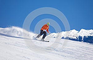 Sportsman in ski mask sliding fast while skiing