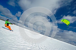 The sportsman on a snowboard runs kite