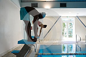 Sportsman and sportswoman getting ready to dive into water