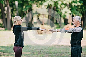 Sportsman and sportswoman looking at each other while training in park