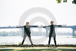 Sportsman and sportswoman looking at each other while training on riverside in park