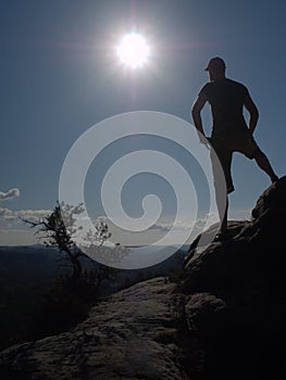 Sportsman stay in akimbo pose looking into hilly landscape