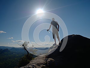 Sportsman stay in akimbo pose looking into hilly landscape