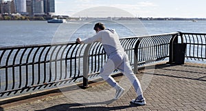Sportsman stretching his muscles and preparing for workout routine of athlete outdoor in New York city