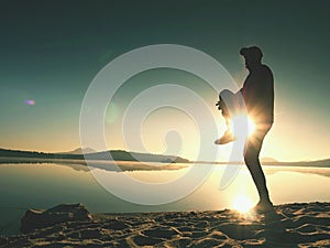 Sportsman stretching after sport at the sea at sunrise in morning. Athlete bending back
