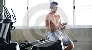 Sportsman  taking a break after training at the gym sitting  and drinking water at sport club. Fitness Healthy lifestye and