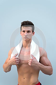 Sportsman with towel on neck on grey background