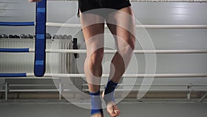Sportsman training on jumping rope at boxing ring. Boxer man training jumping exercise on skipping rope in fighting club