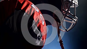 Sportsman in uniform fixing his helmet ready to attack, isolated. Concept of professional team sport. Silhouette of