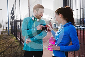 Sportsman using phone to listen to music while running and joggi