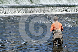 Sportsman in Waders Fishing at Dam photo